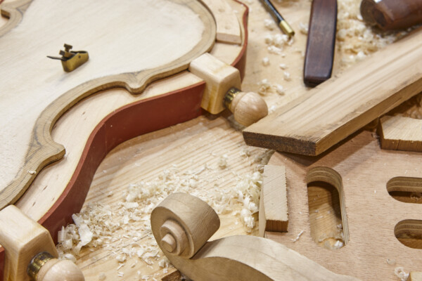 Luthier workshop with violin wooden parts and tools. Traditional craftmanship.